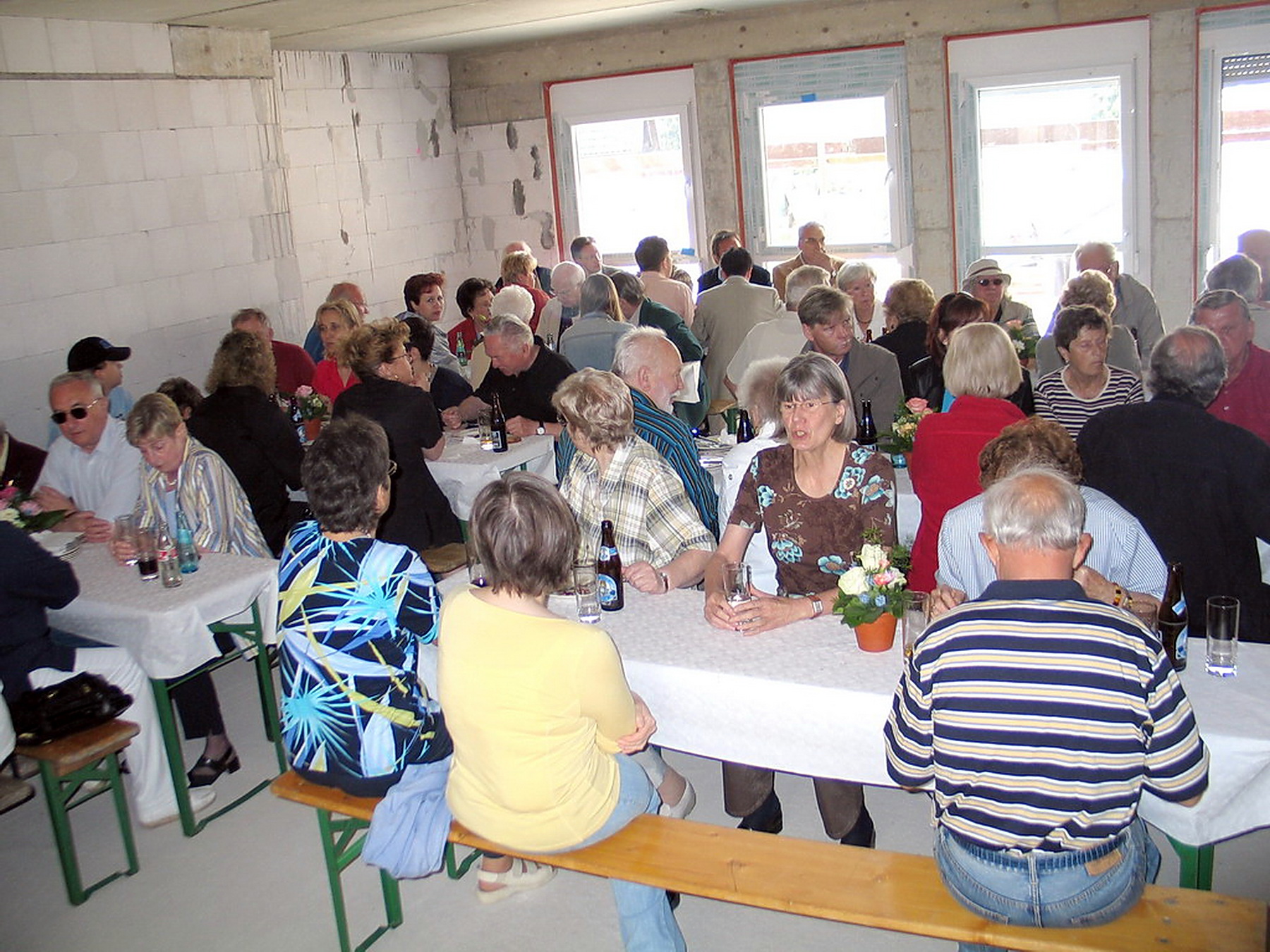 Bauleute, Handwerker, künftige Bewohner und Nachbarn feiern in den Räumen der Anlage