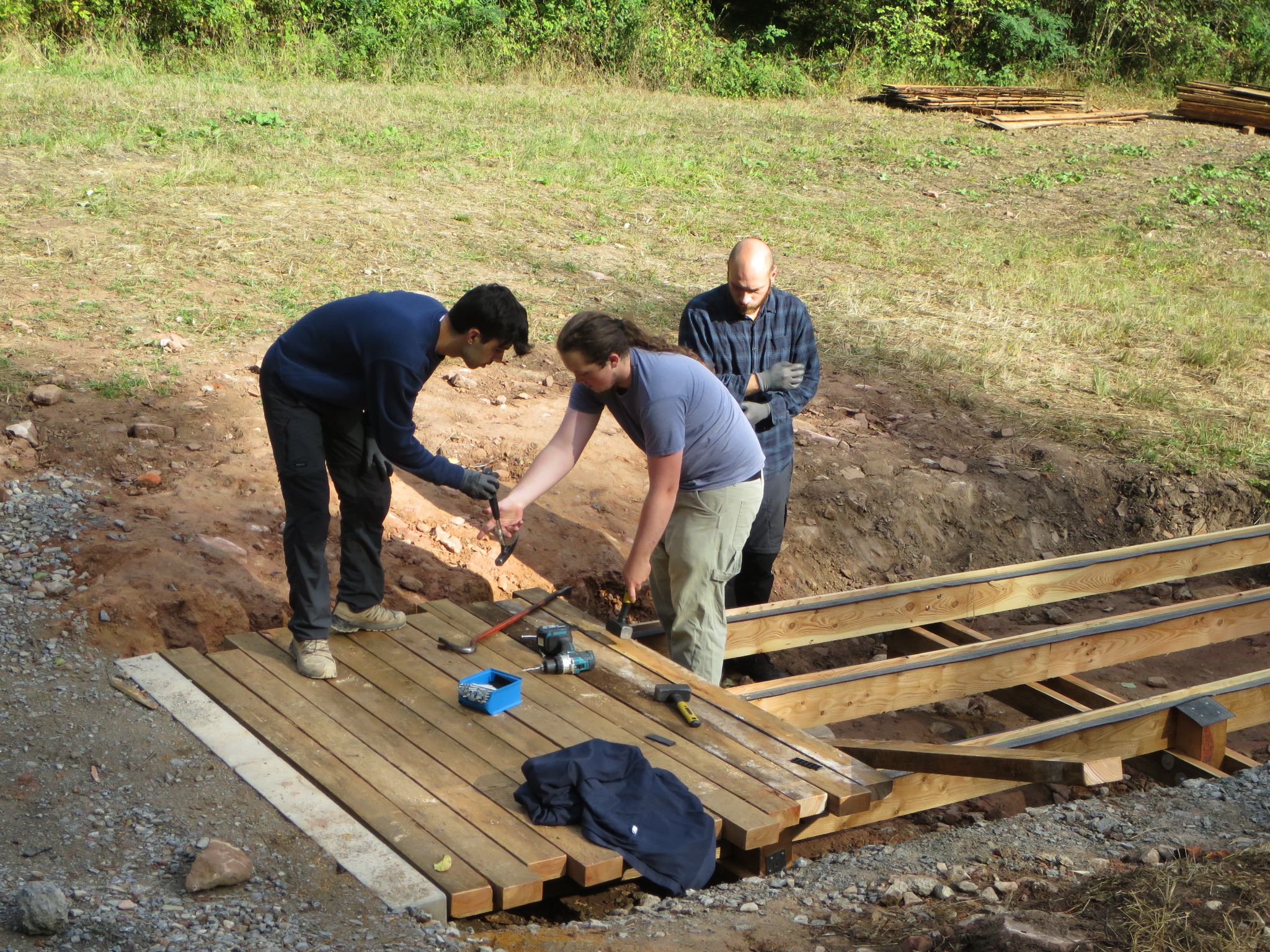 Die ersten Planken am Holzsteg werden verlegt